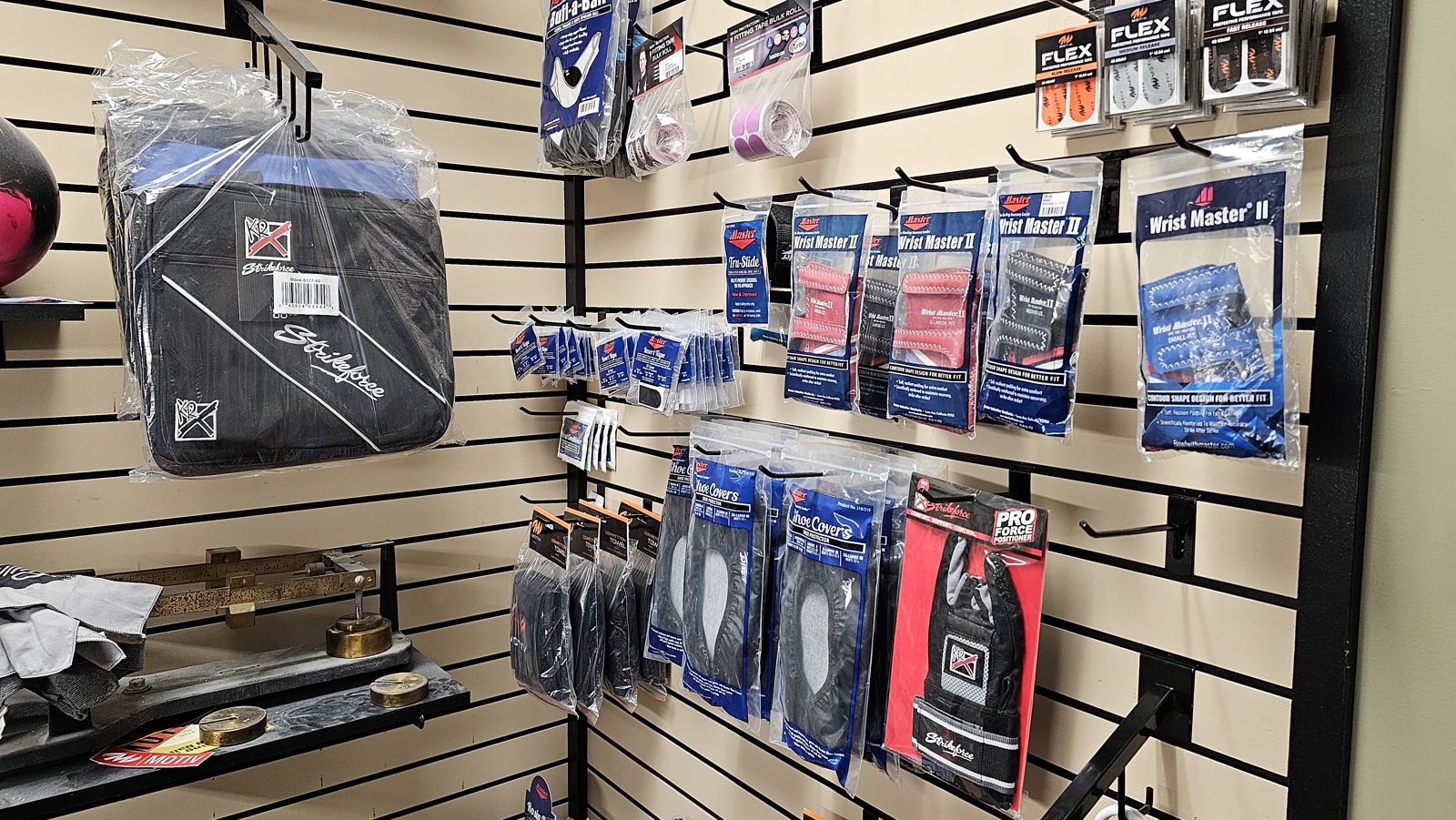Bowling bag, wrist supports, gloves, shoe covers, towels and tape on the pro shop wall