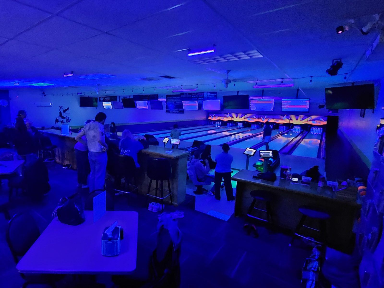 Blacklight bowling at Back Alley After Dark, with the glowing pin area at the end of the lanes