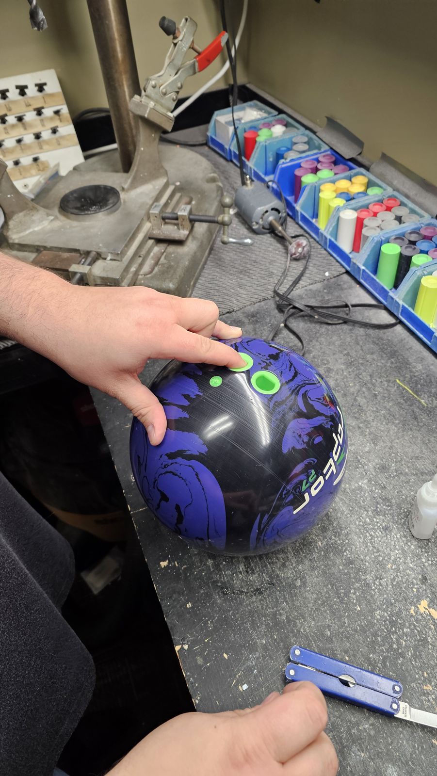 Tim fitting green finger grips into a freshly drilled bowling ball