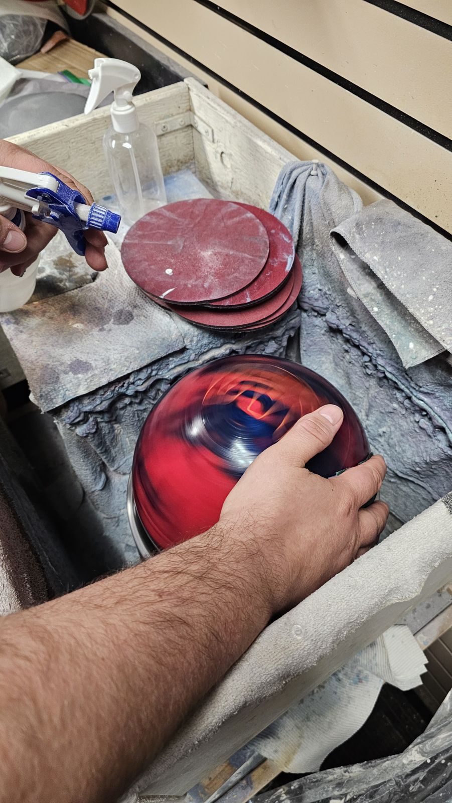 Tim resurfacing a red bowling ball on the spinner